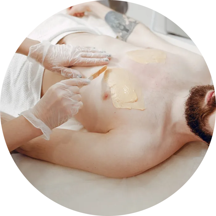 An esthetician applying soft wax during a men's chest wax
