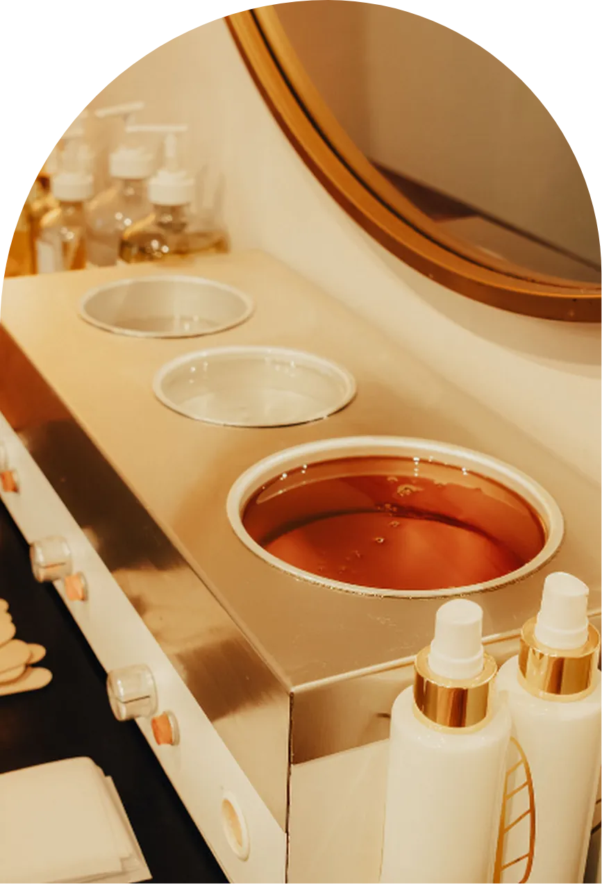 Soft wax warming in gold pots at Wax &amp; Lash Berkeley